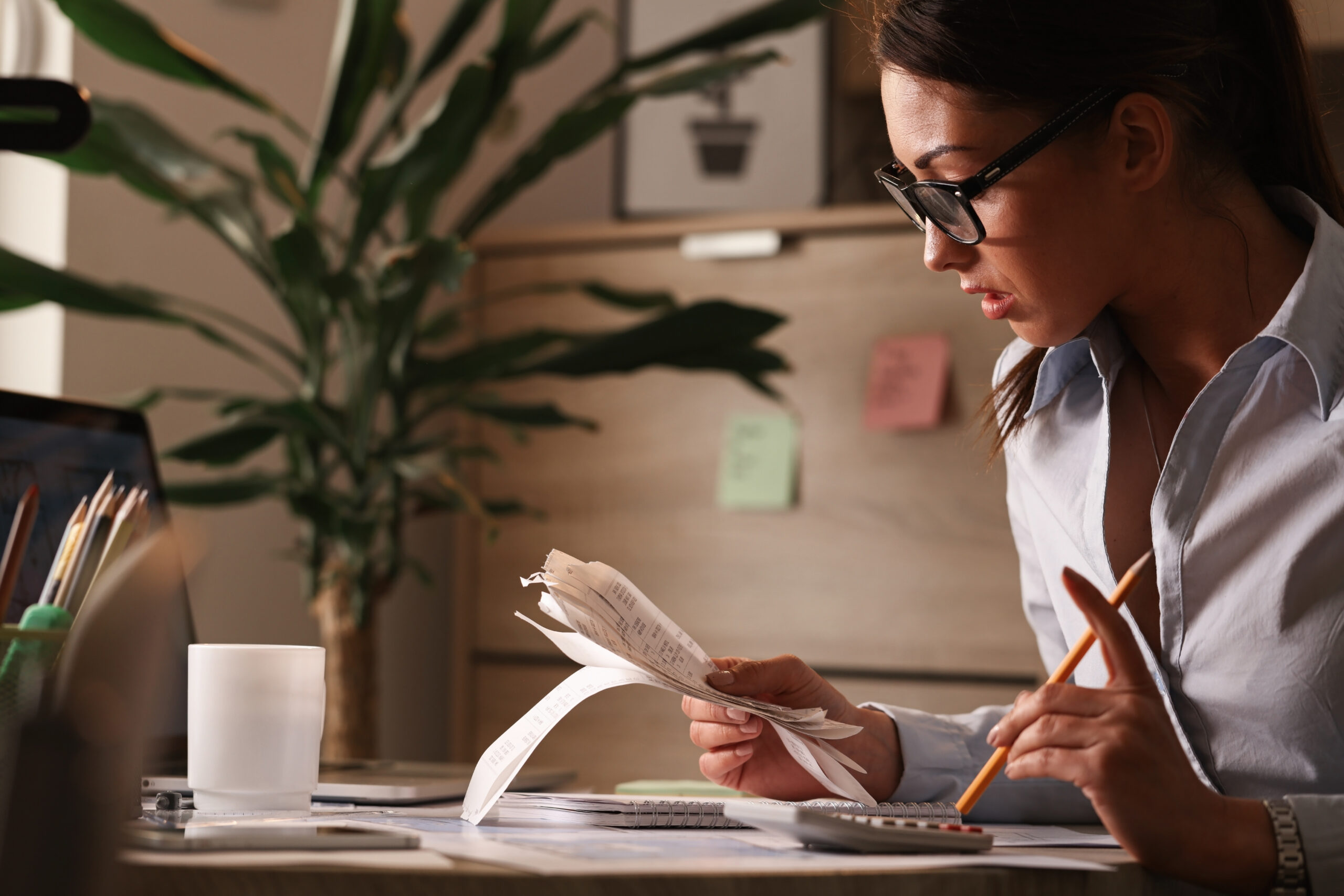 Female accountant calculating tax bills while working on finances in the office.